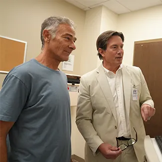 Denver Health patient Bob Klein stands with orthopedic surgeon Mark Hammerberg, MD looking at an Xray.